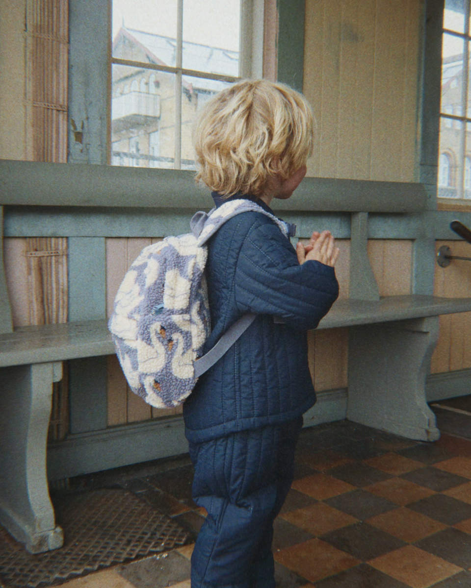 Konges Sløjd Jody Teddy Rucksack in Blau mit Schwanenmuster - Seitenansicht getragen