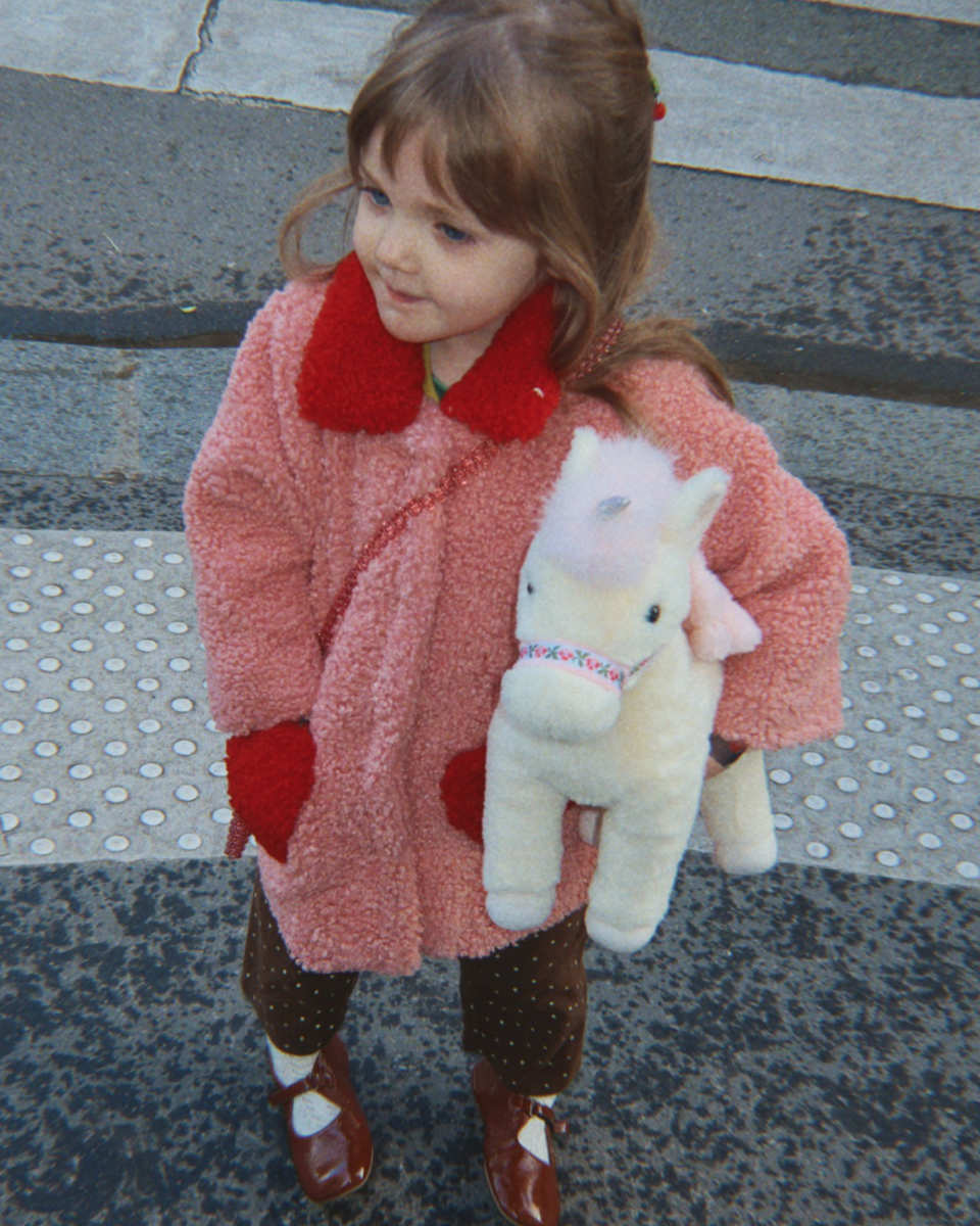 Konges Sløjd Starlight Einhorn Kuscheltier in Weiß - am Kind getragen Ansicht